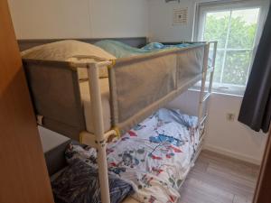 מיטה או מיטות קומותיים בחדר ב-Camping Goedereede Chalet nr 16