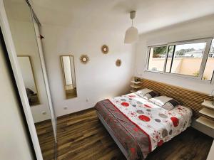 1 dormitorio con cama y ventana en La Petite Maison du Bassin d'Arcachon - 40 m2, climatisée, indépendante et au calme en Audenge