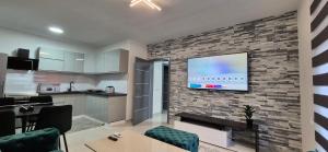 a living room with a tv on a brick wall at Djurdjevik Home in Živinice