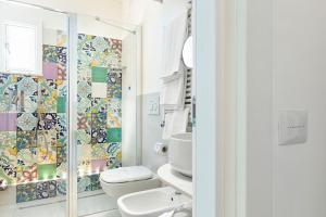 a bathroom with a toilet and a glass shower at Amalfi Suite Boutique Hotel in Amalfi