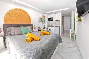 Un dormitorio con una cama grande con dos almohadas amarillas. en Apart hotel Ponderosa with a pool & view, studio 226, en Playa Fañabe