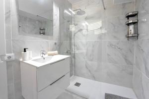 Un baño blanco con lavabo y ducha. en Apart hotel Ponderosa with a pool & view, studio 226, en Playa Fañabe