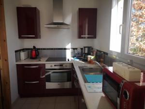 una cocina con fregadero y estufa en PLEHEREL PLAGE Location saisonnière 4-5 personnes, en Fréhel