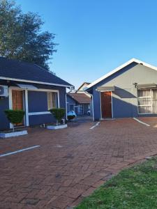 ein Haus mit einer steinernen Einfahrt davor in der Unterkunft Alimop Bed and Breakfast in Midrand