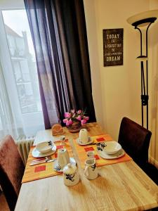 een houten tafel met borden en bekers erop bij Apartment Jackie in Bielefeld