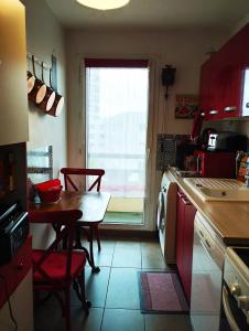 eine Küche mit einem Tisch, einem Tisch und einem Fenster in der Unterkunft Appartement JO tout confort in Alfortville