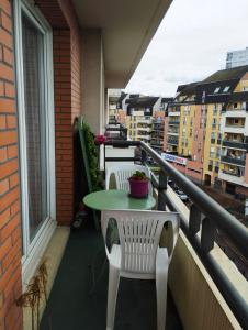einen Balkon mit einem Tisch, 2 Stühlen und einem Fenster in der Unterkunft Appartement JO tout confort in Alfortville