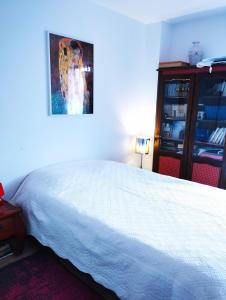 ein Schlafzimmer mit einem weißen Bett und einem Gemälde an der Wand in der Unterkunft Appartement JO tout confort in Alfortville
