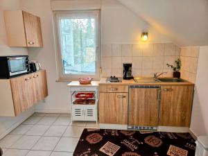 una pequeña cocina con armarios de madera y fregadero en Apartment Jackie, en Bielefeld