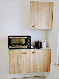 eine Mikrowelle auf einem Schrank in einer Küche in der Unterkunft Apartment Jackie in Bielefeld