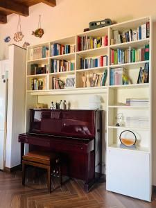 a library with a piano in a room with books at MeiMà Apartment Hanbury’s Gardens in Mortola Inferiore
