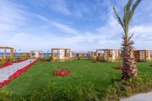 um resort com uma palmeira e flores na relva em Rixos Radamis Sharm El Sheikh em Sharm el Sheikh