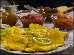 un plato de huevos revueltos y pimientos en una mesa en Haer B&B, en Meghri