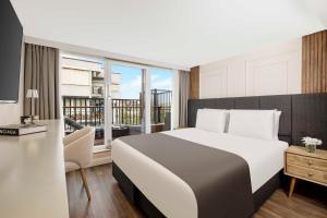 a bedroom with a large bed and a balcony at Nardi Nişantaşı in Istanbul