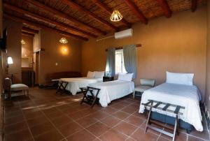 een kamer met 2 bedden en een tafel en stoelen bij Hotel de campo luna in Tinogasta