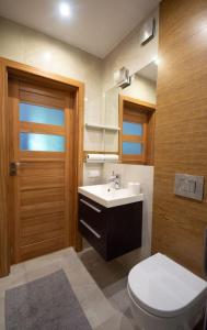 La salle de bains est pourvue de toilettes, d'un lavabo et d'une porte. dans l'établissement Duże mieszkanie, ogród i parking, à Radwanice