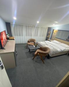 een slaapkamer met een bed en 2 stoelen en een bureau bij Kadıköy Linda Hotel in Istanbul