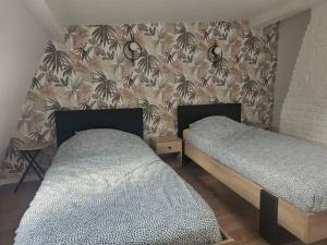 twee bedden in een slaapkamer met een muur met palmbomen bij Le duplex Clieu BY HOLIDIEPPE in Dieppe