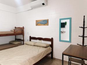 a bedroom with two bunk beds and a table at Casinhas Terõ - in São Sebastião