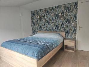 een bed met een blauw dekbed in een slaapkamer bij Le duplex Clieu BY HOLIDIEPPE in Dieppe +16 foto's