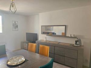 een eetkamer met een tafel en een spiegel bij Le duplex Clieu BY HOLIDIEPPE in Dieppe