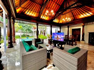 a living room with couches and a flat screen tv at Mai Villa in Jimbaran