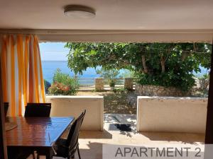 a dining room with a table and a view of the ocean at Apartmani Denis in Stara Baška