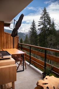 uma varanda com uma mesa e vista para uma montanha em Studio cabine « Au Loup Blanc » em Saint-Gervais-les-Bains