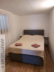 a bedroom with a bed with two towels on it at Apartmani Denis in Stara Baška