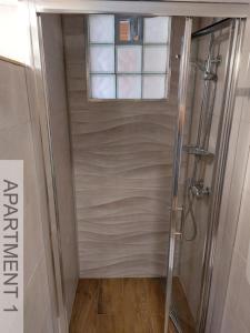 a shower with a window in a bathroom at Apartmani Denis in Stara Baška