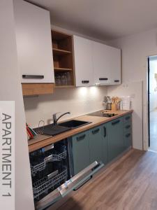 a kitchen with white cabinets and a sink at Apartmani Denis in Stara Baška