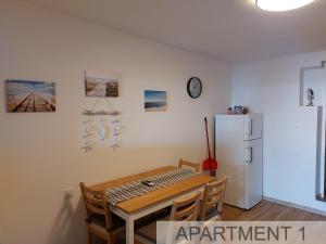 a dining room with a table and a refrigerator at Apartmani Denis in Stara Baška +27 photos