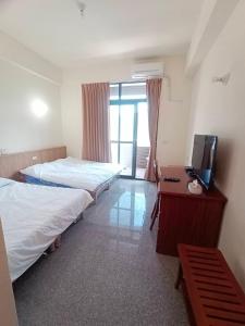 a hotel room with two beds and a television at 長龍客棧 in Nantou City +24 photos