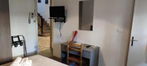a room with a tv and a mirror on a wall at Villa Liberty Versilia in Lido di Camaiore