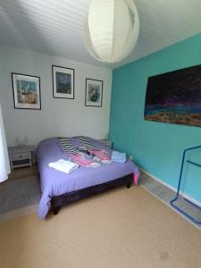 a bedroom with a bed with a blue wall at LE GITE DE BRI in Orbey