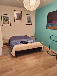 a bedroom with a bed and a painting on the wall at LE GITE DE BRI in Orbey