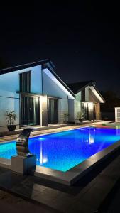 a swimming pool in front of a house at night at Anjung Barakah Chalet in Kuala Terengganu