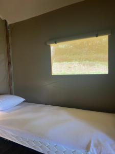 een kleine slaapkamer met een bed en een raam bij lodge lavallee in Belvédère