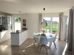 a kitchen and dining room with a table and chairs at Ferienhaus Wiesenkate in Hohwacht