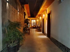 a hallway with potted plants in a building at Zhangjiajie Tingyutang Little Yard in Zhangjiajie