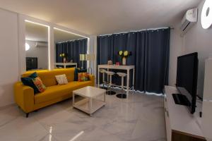 een woonkamer met een gele bank en een tv bij Colourful Bright Centred Apt. with Ocean View in Playa Fañabe