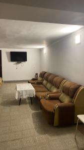 sala de estar con sofá grande y TV de pantalla plana en Asatryan’s Guest House en Vagharshapat