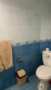 a bathroom with a white toilet and blue tiles at Asatryan’s Guest House in Vagharshapat