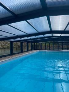 una piscina cubierta con un techo de agua azul en Maison d'hôtes & Gîtes Domaine de la Garaye, en Dinan