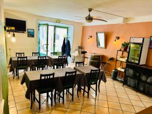 een eetkamer met tafels en stoelen en een keuken bij Hôtel Restaurant La Forge in Castellane