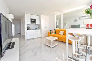 een woonkamer met een gele bank en een keuken bij Colourful Bright Centred Apt. with Ocean View in Playa Fañabe