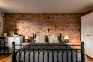 リガにあるArs Vivendi Rezidenceのレンガの壁とベッドが備わるベッドルーム1室が備わります。