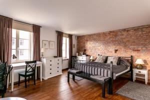 a bedroom with a brick wall and a couch at Ars Vivendi Rezidence in Rīga