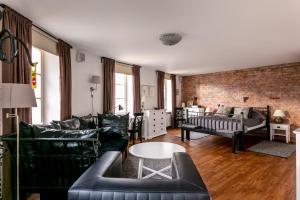 ein Wohnzimmer mit schwarzen Möbeln und einer Ziegelwand in der Unterkunft Ars Vivendi Rezidence in Riga