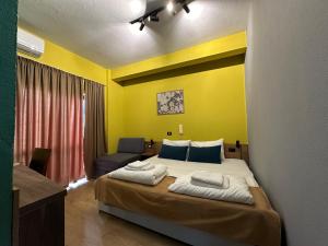 a bedroom with a large bed and a yellow wall at VILLA CABARE Apartments&Rooms in Durrës